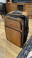 Front and side view of orange Samsonite softside wheeled duffel
