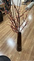 Tall brown ceramic vase with berry stems arrangement front view