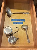 Drawer view: sterling gravy ladle, two sterling cups, detached handle, nickel silver serving ladle