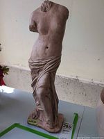 Full rear view of headless Venus de Milo style statue on base