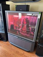 Front view of Sony rear-projection TV powered on displaying image