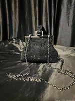 Front view of black rhinestone mini clutch showing chain strap and metal frame