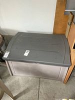 Front view of resin deck box with grey lid and light grey body