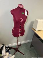Full view of burgundy adjustable dress form on stand
