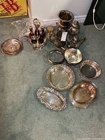 Group shot of all silver-plated items and cutlery bags on carpet