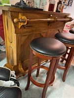 Front view of wood bar with hand rail and two bar stools