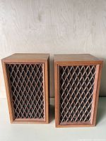 Front view of both Pioneer CS-44 speakers showing wood veneer cabinets and diamond-lattice grilles