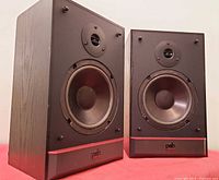 Front angled view of both uncovered speakers showing drivers and cabinet condition