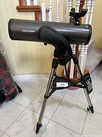 Left-side view of telescope on tripod with hand controller attached