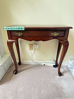 Full front view of wood console table showing overall design, drawer, legs