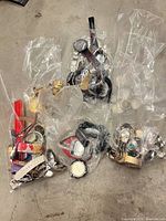 Four clear bags filled with assorted wristwatches, watch heads, bands and parts