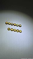 Top and bottom rows of ten yellow sapphire cabochons under light