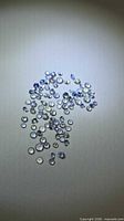 Group of small round faceted blue-violet tanzanite stones spread on surface