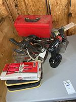 Overall lot showing toolbox on top, cordless drill, clear bin of hand tools and boxed screwdrivers