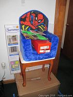 Photo of Spiderman children's chair on a small wooden bench with boxed baby gate leaning against the wall.