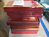 Stack of red original Lenox ornament boxes with gold trim.