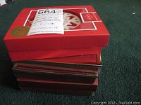 Stacked red boxes containing Lenox ornaments with label