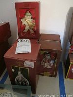 Photo showing multiple Lenox glass ornaments in original red boxes, including a large gingerbread figure and snowmen.