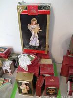 Hallmark Keepsake ornament boxes arranged showing Angel of Light as the tallest box in background along with other boxes stacked on a flat surface