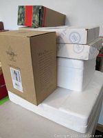 Stack of original cardboard boxes for fragile Bradford Exchange ornaments including Willow Tree brand with visible product label.