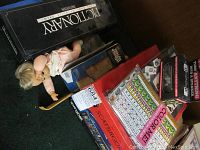 Photo shows Pictionary, Jenga, Scattergories, Color Me packs, and a baby doll placed on top of a pile of boxed games and toys.
