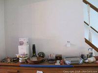 Overview of lot on table including Google Home devices, clocks, decorative items, and tool set.