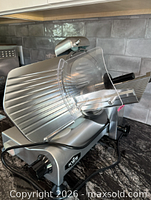 Side view of silver KWS slicer with power cord and blade guard