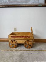 Side view of wagon showing Saskatchewan Wheat Pool logo, wheels, pull handle and scale ruler