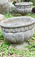 Both gray concrete urn planters outdoors
