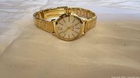 Front view of gold-tone quartz wristwatch open bracelet