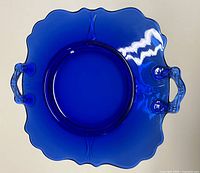 Top view of cobalt blue glass cake plate showing handles and scalloped edges