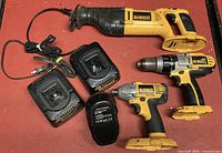 All items laid out: saw, drill, impact driver, two chargers, two batteries