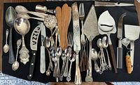 Full layout of all serving utensils and spoons on black background