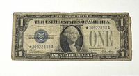 Obverse of the 1928-A $1 silver certificate showing blue seal, star serial number *30922898A, wear and creases