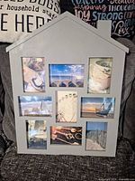 Front view of light gray house-shaped collage frame showing all nine photo windows
