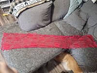 full view of red lace table runner laid out on sofa