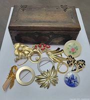 Group shot of wooden box with all brooches displayed