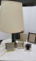Lamp with shade and five assorted frames grouped together