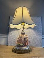 Full view of porcelain figural lamp with shade