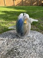 Full view of art glass sculpture on stone showing overall form and fins