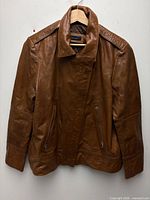 Full front view of brown leather jacket on hanger