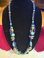 Full view of necklace on display bust showing bead arrangement and length