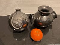 Front view of both black pottery vases with size reference