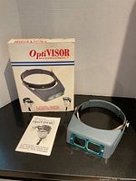 OptiVISOR headset, box and instruction pamphlet displayed