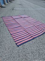 Full view of striped plastic mat laid flat on gravel