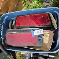 Pair of saddlebags in tote showing red lids and black sides