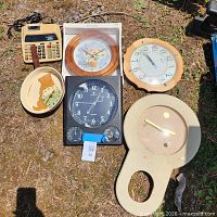 Group shot of all clocks and calculator laid on ground
