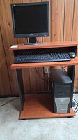 Front view of cherry laminate desk with keyboard shelf, monitor and PC shown for scale