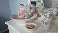 Entire four-piece wash set on dresser with mirror