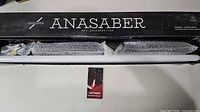 Original Anasaber box opened showing two bubble-wrapped lightsabers, white blades and USB cables